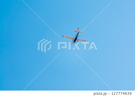 Small ultralight airplane with overhead wing and single propeller flying in sunset sky. Small ultralight airplane with overhead wing and single propeller flying in sunset sky. 127774639
