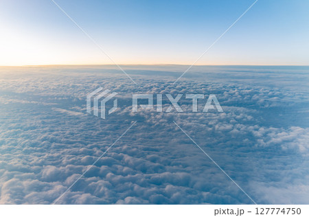 Beautiful orange and pink sunrise over the clouds, view from the plane. 127774750