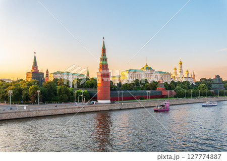 View of Kremlin with Vodovzvodnaya tower, Grand Kremlin Palace from repaired Bolshoy Kamenny Bridge in Moscow city on sunny summer day. Cruise ship sails on the Moscow river 127774887