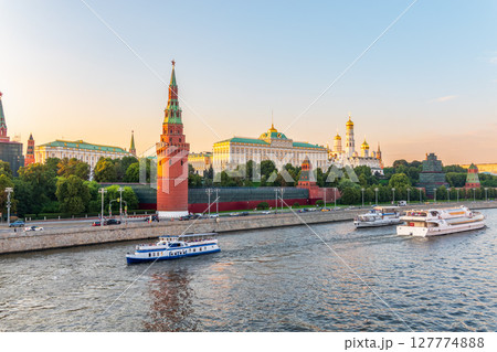 View of Kremlin with Vodovzvodnaya tower, Grand Kremlin Palace from repaired Bolshoy Kamenny Bridge in Moscow city on sunny summer day. Cruise ship sails on the Moscow river 127774888