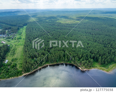 Aerial view of lake or river green shore with forest. Summer season. Aerial view of lake or river green shore with forest. Summer season. 127775038