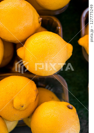 Closeup lemons In fruit market display, outdoor farm market stall 127775249
