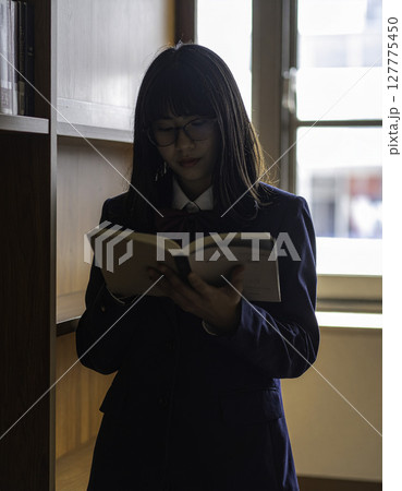 静寂に包まれて本と向き合う女子高校生 127775450