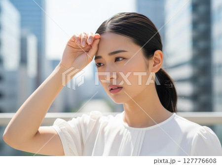 汗を拭う女性　猛暑　夏 127776608
