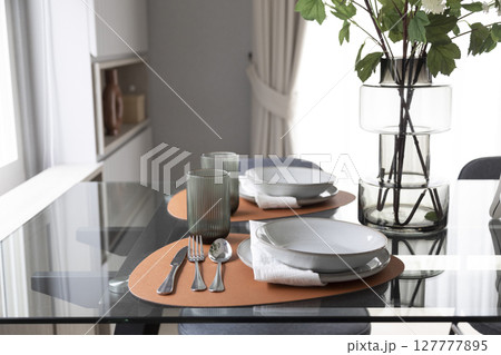 dining table with black and white plate setting in modern home. dining table with black and white plate setting in modern home. 127777895