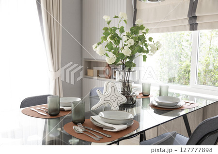 dining table with black and white plate setting in modern home. dining table with black and white plate setting in modern home. 127777898