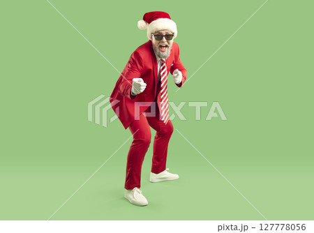 Full length shot of fashionable Santa Claus in elegant red suit having fun indicating at you Full length shot of fashionable Santa Claus in elegant red suit having fun indicating at you 127778056
