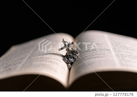 Religious belief concept Close up prayer Christian church service Bible Holy cross Spiritual power Blurred background Desk copy space Heaven God Catholic faith Praise book Jesus worship Gospel symbols 127778176