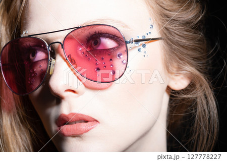 Woman with sunglasses and glued jewelry close-up studio portrait Woman with sunglasses and glued jewelry close-up studio portrait 127778227