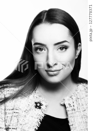Beautiful woman with long dark hair studio portrait 127778371