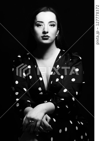 Beautiful woman with long dark hair black and white studio portrait 127778372