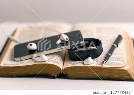 Close-up religious technology headphones pray bible church laptop Jesus Christ Holy Spirit Sunday service spiritual power blur background phone concept heaven belief gospel faith praise worship god 127778422