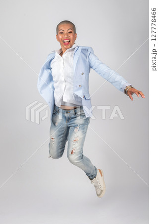 Happy Thai woman with suit and jeans jumping in air Happy Thai woman with suit and jeans jumping in air 127778466