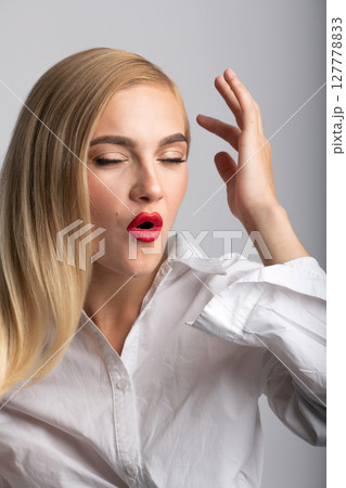 Beautiful blonde woman with long hair and red lipstick close-up studio portrait Beautiful blonde woman with long hair and red lipstick close-up studio portrait 127778833