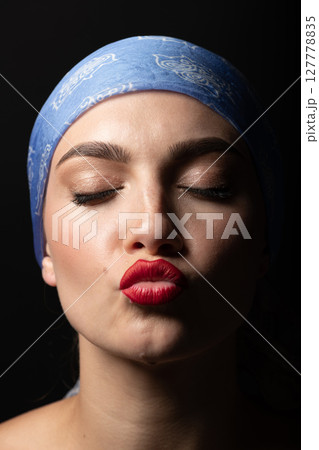 Studio portrait of a young woman sending kiss 127778835