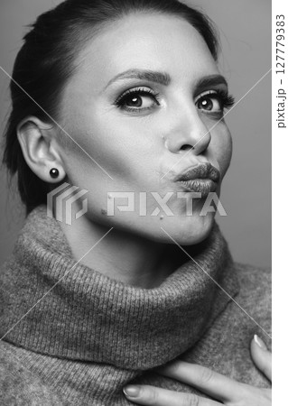 Studio portrait of beautiful woman sending kiss to camera Studio portrait of beautiful woman sending kiss to camera 127779383