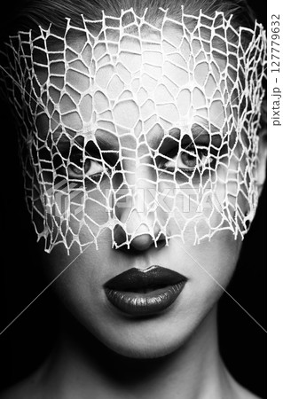Beautiful woman with fancy make-up and abstract face mask studio portrait 127779632