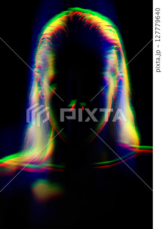 Studio portrait of woman silhouette partly illuminated with light in RGB color split effect style Studio portrait of woman silhouette partly illuminated with light in RGB color split effect style 127779640