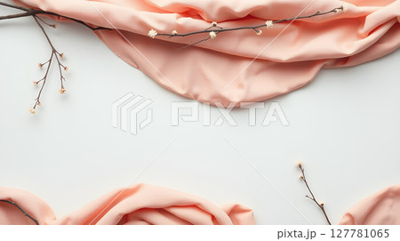 Elegant peach fabric and sprig on a bright white background, perfect for a minimalist aesthetic. 127781065