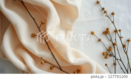 Soft beige fabric with delicate brown sprigs and a textured white surface, close-up shot 127781200