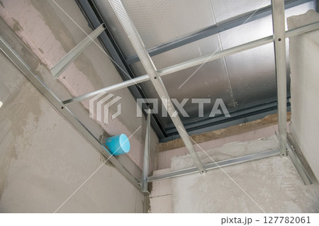 Detailed view of an aluminium ceiling framework with new electrical wiring. interior renovation project shows metal stud installation for new suspended ceiling Detailed view of an aluminium ceiling framework with new electrical wiring. interior renovation project shows metal stud installation for new suspended ceiling 127782061