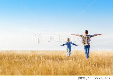 Boys are running on the grass in the open air. 127782485