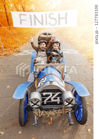 Young racer and mechanic on old race car 127783100