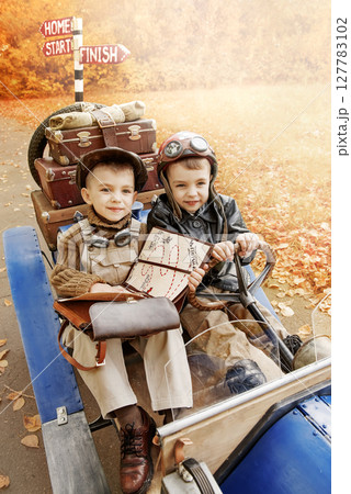 Young racer and mechanic near an old race car 127783102