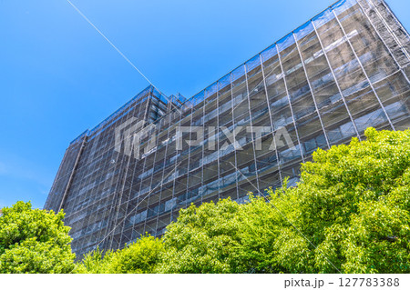 日本の横浜都市景観　マンションの補修や点検等、足場や防護ネットなど。ネットの外に衛星アンテナが… 127783388