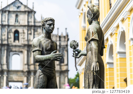 A sculpture of a young man and woman in front of the Ruins of St. Paul's at Jesus Company Square in Macau symbolizes the friendship between China and Portugal. A sculpture of a young man and woman in front of the Ruins of St. Paul's at Jesus Company Square in Macau symbolizes the friendship between China and Portugal. 127783419