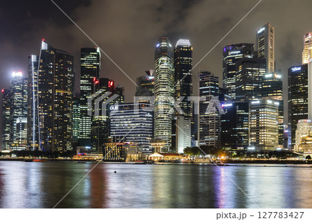 Night view of the Marina Bay Financial Centre and the Raffles Place modern office skyscrapers along Marina Bay in Singapore.  127783427