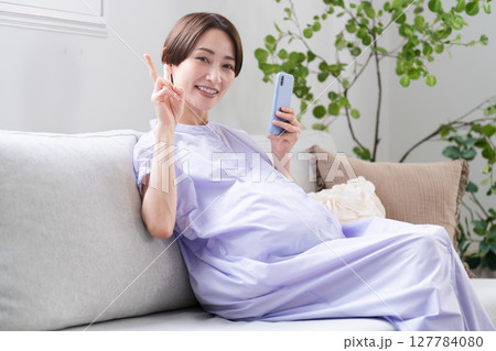 スマートフォンを操作する妊婦　ライフスタイルイメージ 127784080