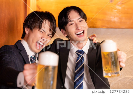 飲み会　居酒屋で乾杯している若者 127784283
