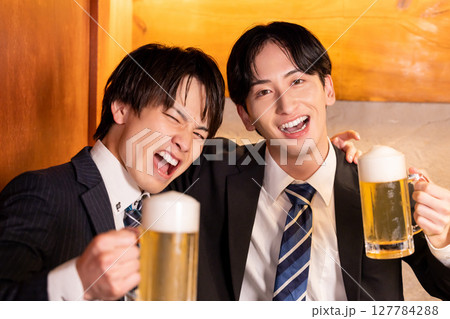 飲み会　居酒屋で乾杯している若者 127784288
