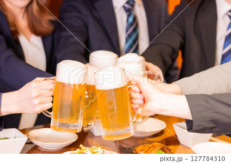 飲み会　ビールで乾杯している手元 127784310