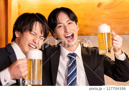 飲み会　居酒屋で乾杯している若者 127784386