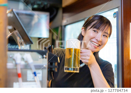 居酒屋　ビールサーバー　ビールを注ぐ女性スタッフ 127784734