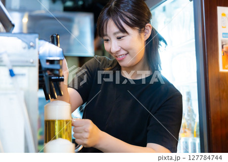 居酒屋 ビールサーバー ビールを注ぐ女性スタッフ 居酒屋 ビールサーバー ビールを注ぐ女性スタッフ 127784744