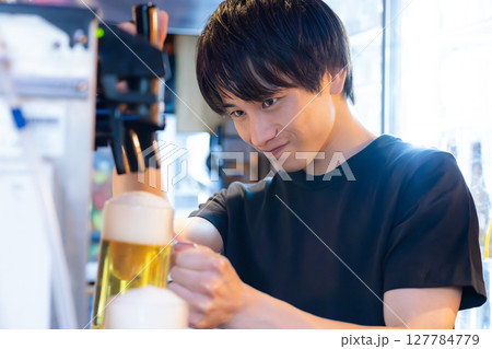 居酒屋　ビールサーバー　ビールを注ぐ男性スタッフ 127784779