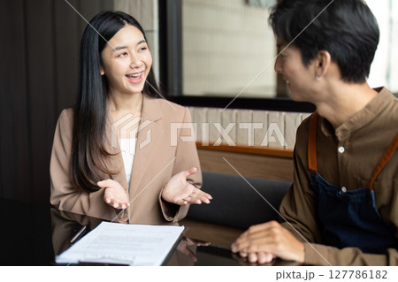 Entrepreneurial Discussion. Young professional explaining ideas in a cafe setting. 127786182