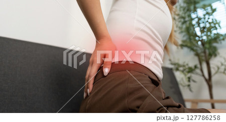 Chronic Pain Management. Young woman experiencing lower back pain at home. Chronic Pain Management. Young woman experiencing lower back pain at home. 127786258