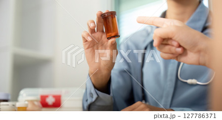 Patient Consultation on Medication. Doctor discussing prescription with a patient in a healthcare setting. 127786371
