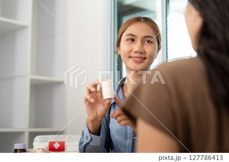 Patient Education on Medication. Smiling healthcare professional explaining prescription to a patient. Patient Education on Medication. Smiling healthcare professional explaining prescription to a patient. 127786413
