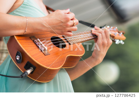 Girl rings ukulele in a show Girl rings ukulele in a show 127786425
