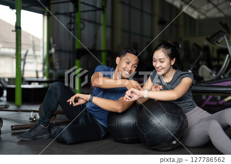 Friends sharing fitness tips at gym. Encouraging each other during workout. 127786562