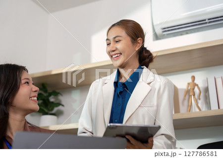 Positive Interaction. Professionals sharing insights and smiling during a meeting. 127786581