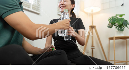Couple sharing joyful moments with water bottles at home Couple sharing joyful moments with water bottles at home 127786655