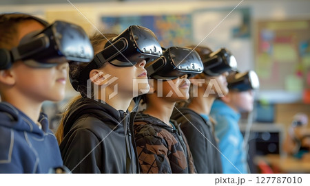 Students explore a captivating virtual world with VR headsets, enhancing their learning together. 127787010