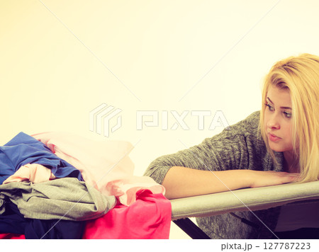 Woman holding iron about to do ironing Woman holding iron about to do ironing 127787223