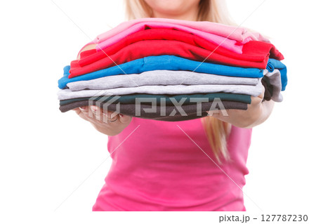 Woman holding folded clothes after ironing 127787230